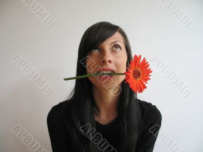 dark hair girl bitting a flower