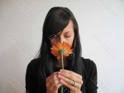 dark hair girl smelling a flower