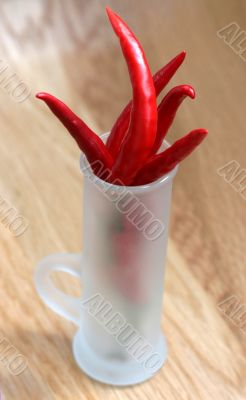 red peppers in a frosted glass on wood table