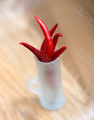 red peppers in a frosted glass on wood table