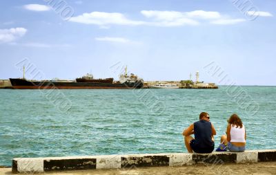 Summer day man and woman sitting at the berth