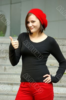 Girls with red cap stretches thumb in the air