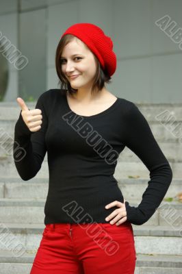 Girls with red cap stretches thumb in the air