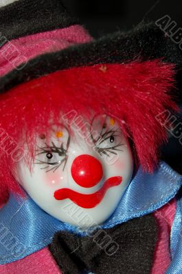 Head of toy clown wearing a black hat