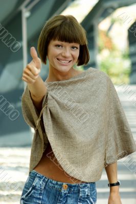 Sexy young woman stretches the thumbs up