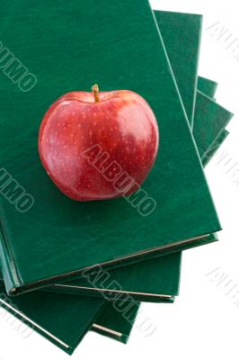 A red apple red on a green book