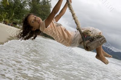Girl on swing at the sea