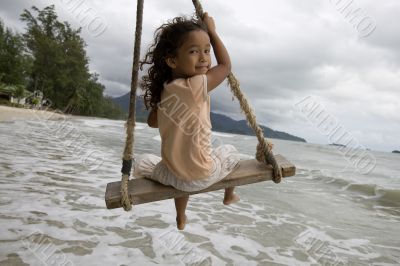 Girl on swing at the sea