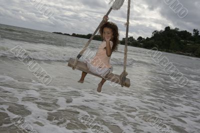 Girl on swing at the sea