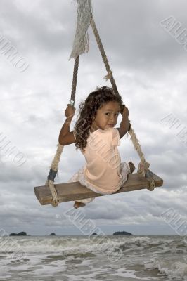 Girl on swing at the sea