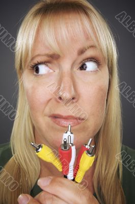 Confused Woman Holding Electronic Cables