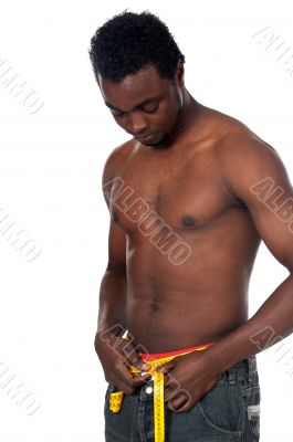 Muscular African boy measuring your waist