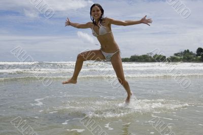 female teenager jumps on the beach