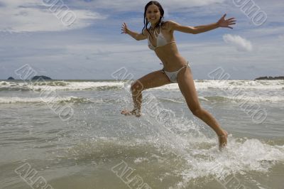 female teenager jumps on the beach