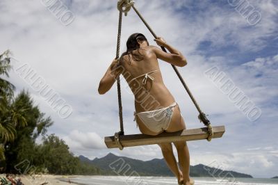 Girl on swing on the beach