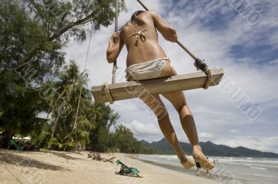 Girl on swing on the beach