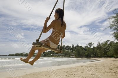 Girl on swing on the beach