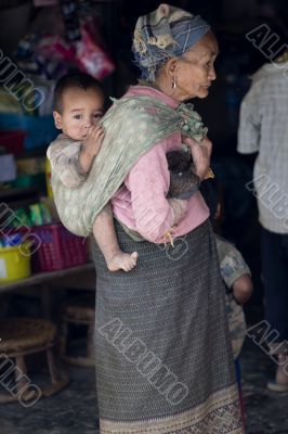 Asia, old woman with grandchild and chicken