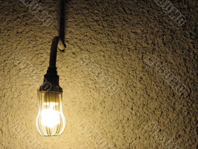 lit lightbulb in front of a wall