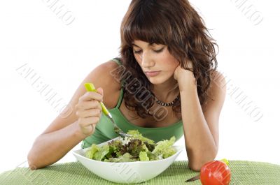 A sad teen eating salad