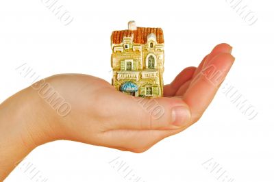 womanish hand holds a toy cottage womanish hand holds a toy cottage