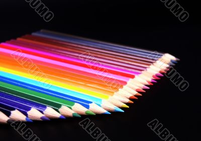 Colorful pencils row isolated on black