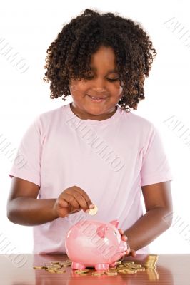 Adorable african girl putting a coin in a piggbank