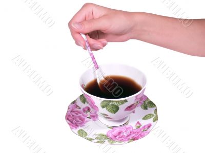 The female hand a spoon stirs tea