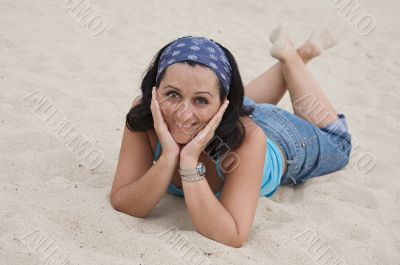 Adorable young woman lie down on the sand
