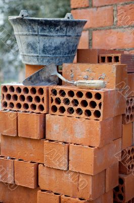 Bricks stacked, trowel and cube in the work