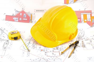 Building plan with safety helmet, pair of compasses and rolling