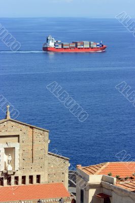 Cantainer cargo ship over Scilla cathedral