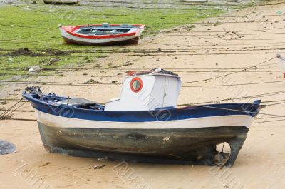 Boat and little fishing ship on the sand with low tide