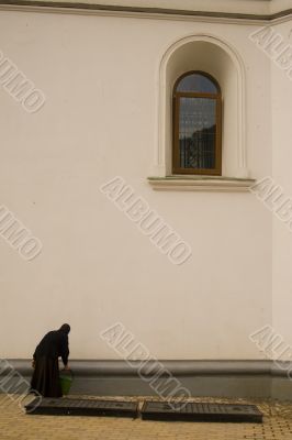 Nun cleaning a wall