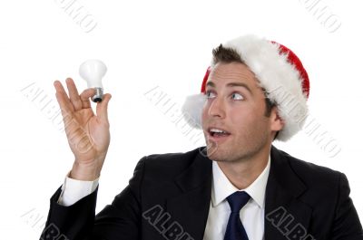 businessman looking bulb and wearing santacap