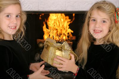 twin sister gift exchange by fireplace