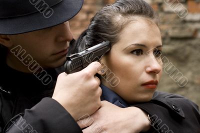 man threatens the woman with a pistol