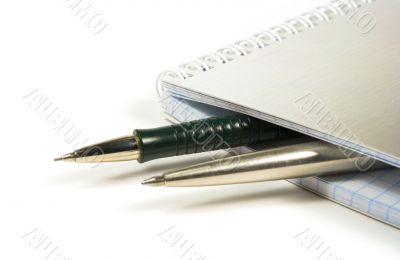 blank notebook and two pens