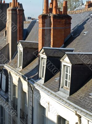 Roofs of a building with pipes and windows
