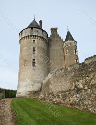 The medieval French castle standing on a grief, against the sky
