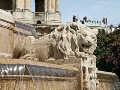 Sculpture of a lion on a fountain on the area in Paris