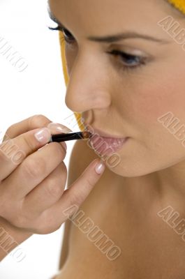 beautician putting lipstick on female`s lips