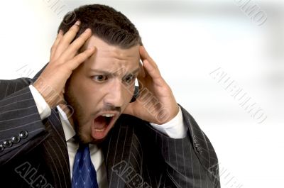 shouting businessman holding his head in his hands