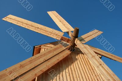 Rural wooden windmill against blue sky