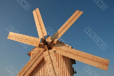 Rural wooden windmill against blue sky