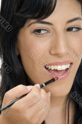 smiling lady putting lipstick