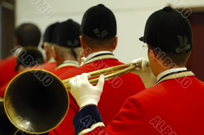 back view of musicians playing on hunting horns