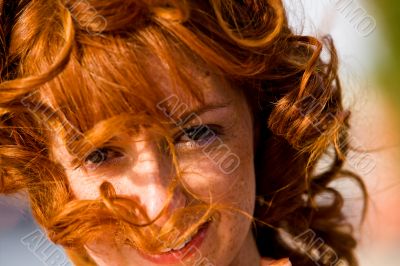 Bright portrait of red-haired young woman outdoors