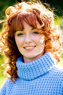 Bright portrait of red-haired young woman outdoors