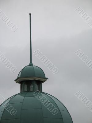 a green church steeple and dark grey sky